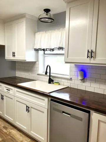 a kitchen with granite countertop a sink stainless steel appliances and cabinets