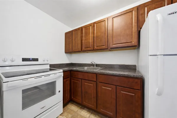 a kitchen with granite countertop cabinets stainless steel appliances and a sink
