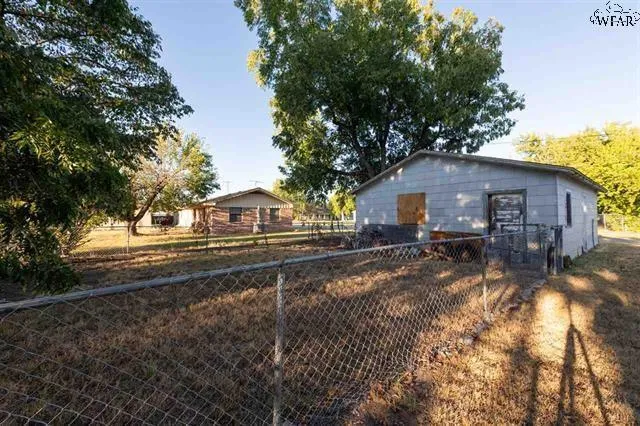 a view of a house with a yard and street