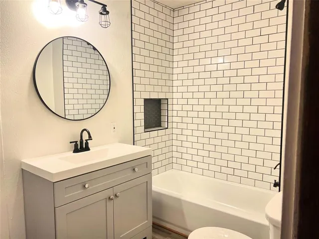 a bathroom with a sink a bathtub and a mirror