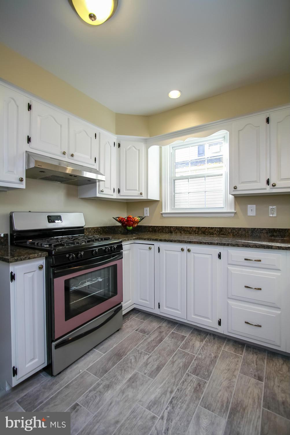 930 Litchfield Road Baltimore, MD 21239 - Photo 10 of 24 a kitchen with granite countertop white cabinets and stainless steel appliances
