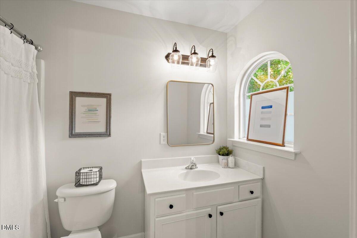 8449 Central Drive Raleigh, NC 27613 - Photo 31 of 38 a bathroom with a toilet a sink and mirror