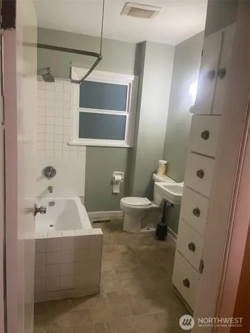 a bathroom with a sink and mirror with toilet