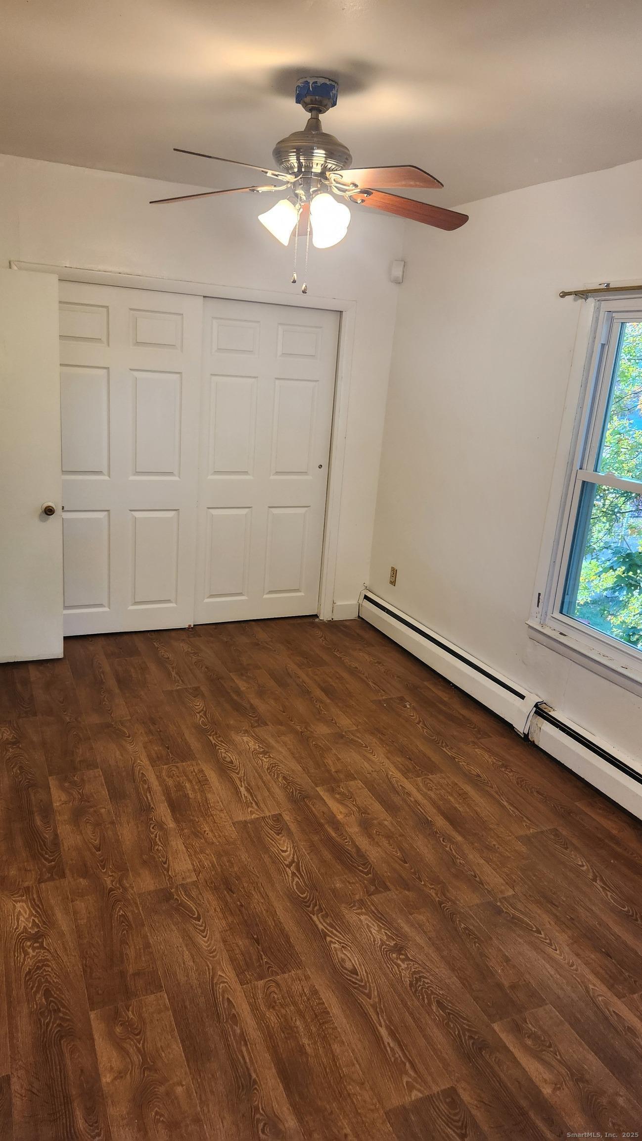 61 Wilson Street New Haven, CT 06519 - Photo 11 of 12 an empty room with wooden floor fan and windows