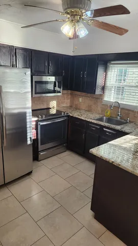 a kitchen with stainless steel appliances granite countertop a sink and a stove