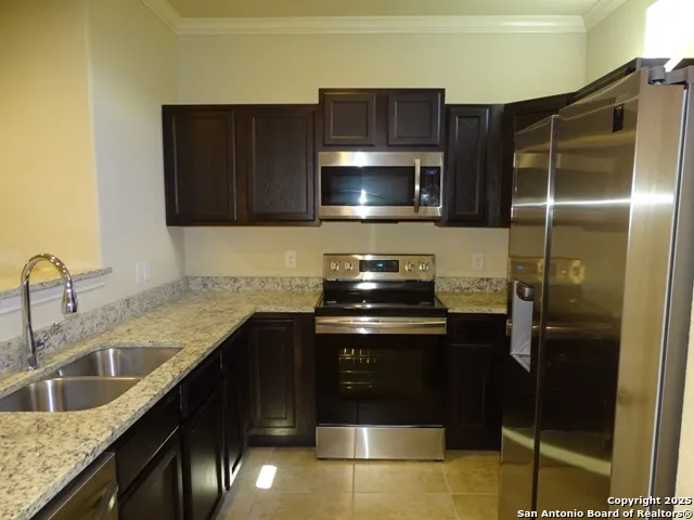 a kitchen with a sink and stainless steel appliances