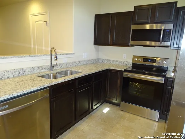 a kitchen with a sink and steel appliances