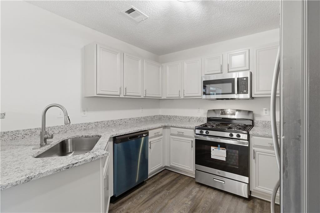 11657 Flemming Court Hampton, GA 30228 - Photo 15 of 30 a kitchen with stainless steel appliances granite countertop a stove a sink and a microwave