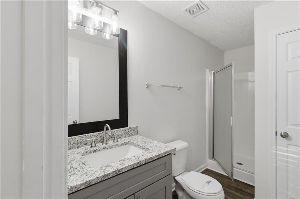 11657 Flemming Court Hampton, GA 30228 - Photo 8 of 30 a bathroom with a granite countertop sink toilet mirror and a vanity