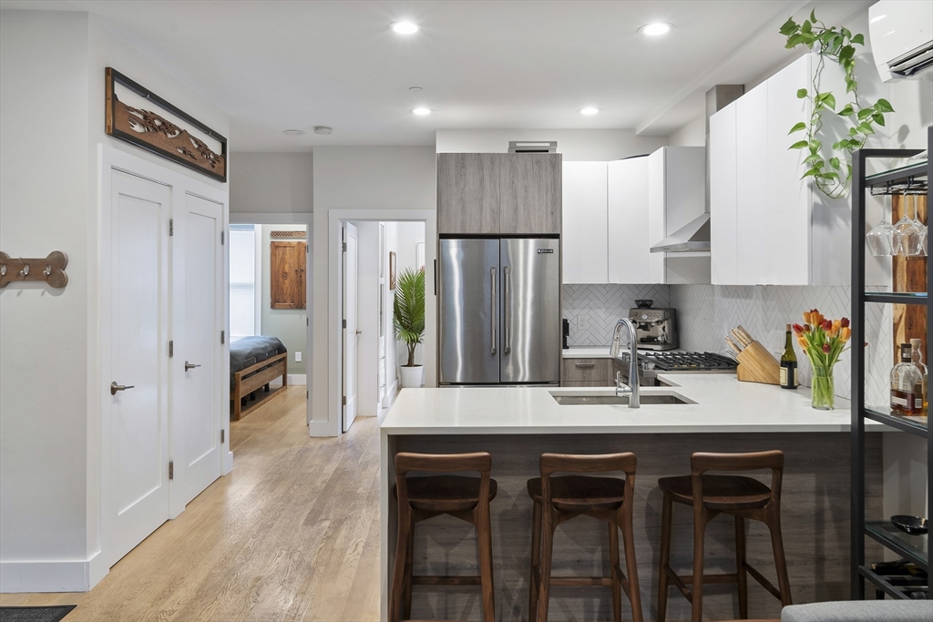 55 East Springfield Street, Unit 2 Boston, MA 02118 - Photo 18 of 22 a kitchen with stainless steel appliances granite countertop wooden floors a refrigerator and a stove