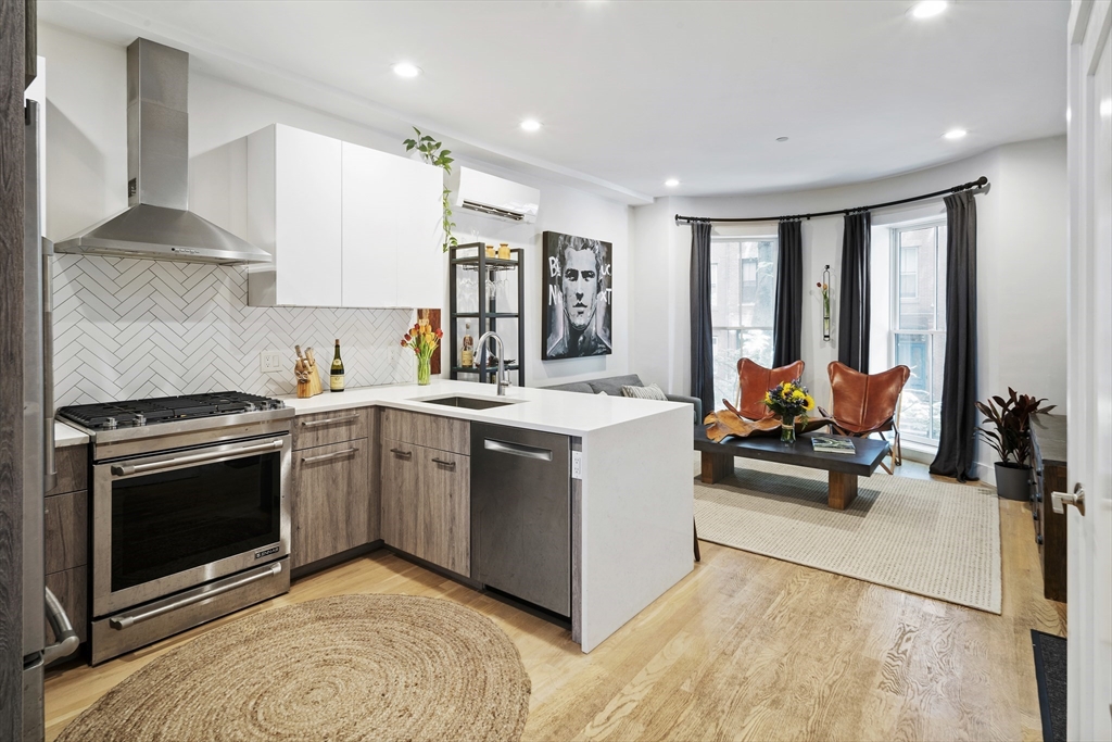 55 East Springfield Street, Unit 2 Boston, MA 02118 - Photo 3 of 22 a kitchen with a sink dishwasher stove and white cabinets with wooden floor