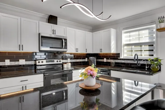 a kitchen with sink a stove and cabinets