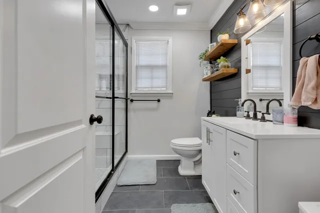 a bathroom with a sink a toilet and shower