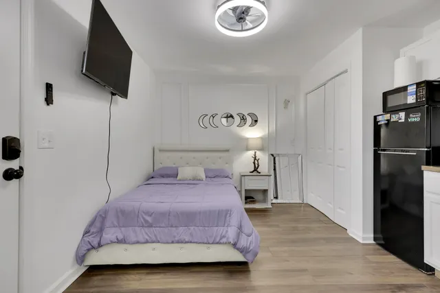 a bedroom with a bed and a flat tv screen