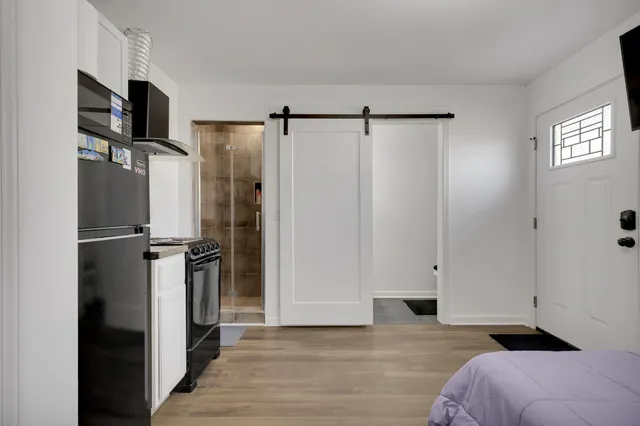 a view of a bedroom with a bed and a refrigerator