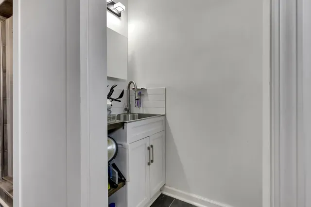 a bathroom with a light fixture a sink and a mirror