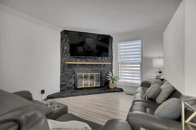 a living room with furniture a flat screen tv and a fireplace