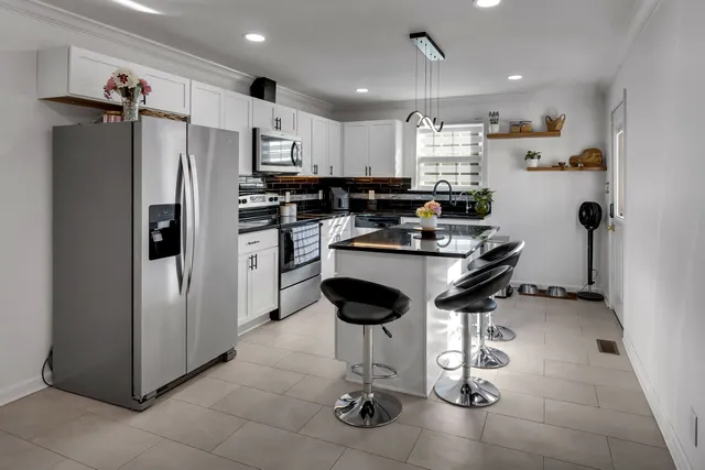 a kitchen with stainless steel appliances granite countertop a refrigerator and a stove top oven