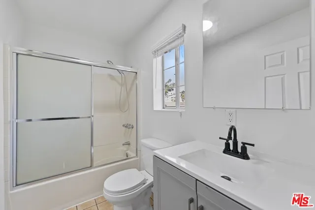 a kitchen with white cabinets and refrigerator