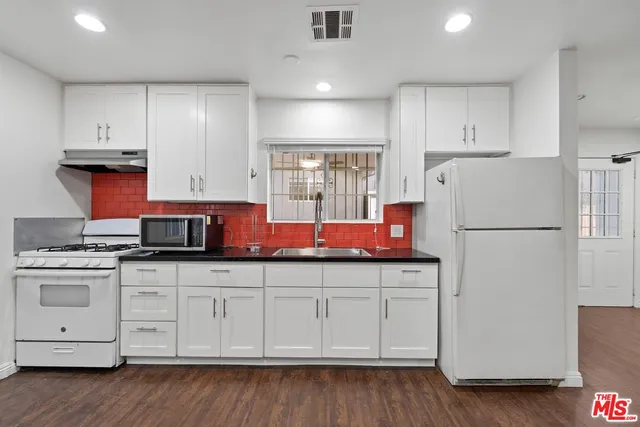 a bathroom with a granite countertop toilet a sink and a mirror