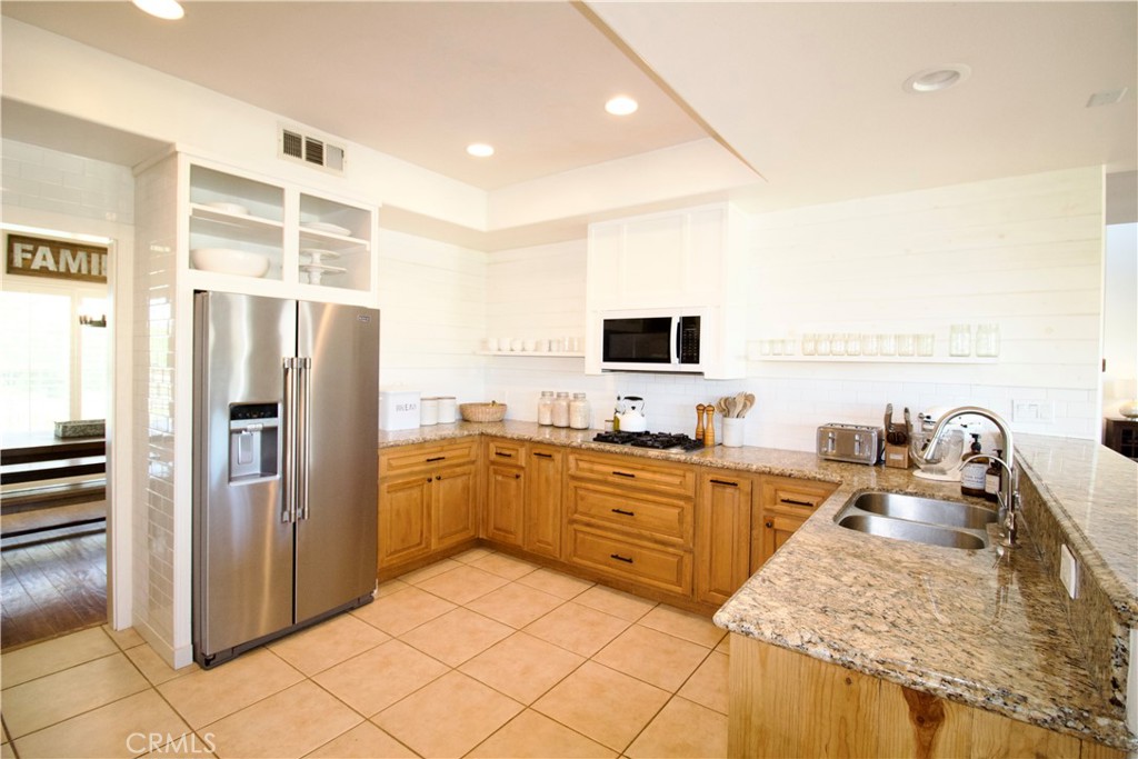 35159 El Dorado Road Lake Elsinore, CA 92530 - Photo 25 of 72 a kitchen with stainless steel appliances granite countertop a refrigerator and a sink