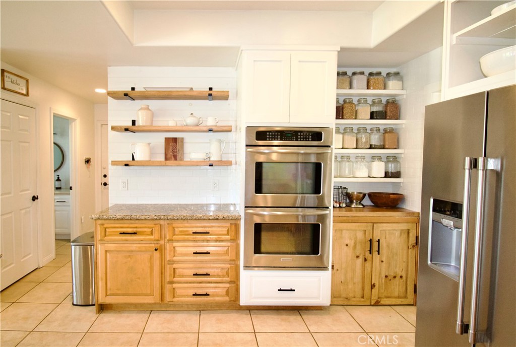 35159 El Dorado Road Lake Elsinore, CA 92530 - Photo 26 of 72 a kitchen with stainless steel appliances a stove a refrigerator and cabinets