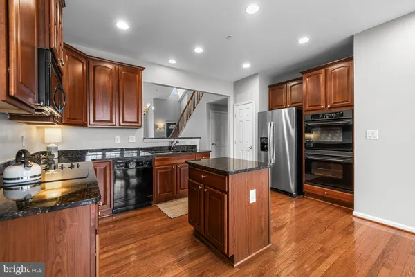a kitchen with stainless steel appliances granite countertop a refrigerator stove and sink