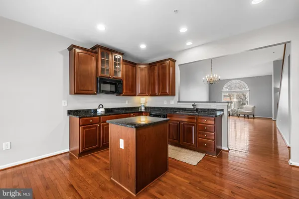 a large kitchen with stainless steel appliances granite countertop a stove and a wooden floors