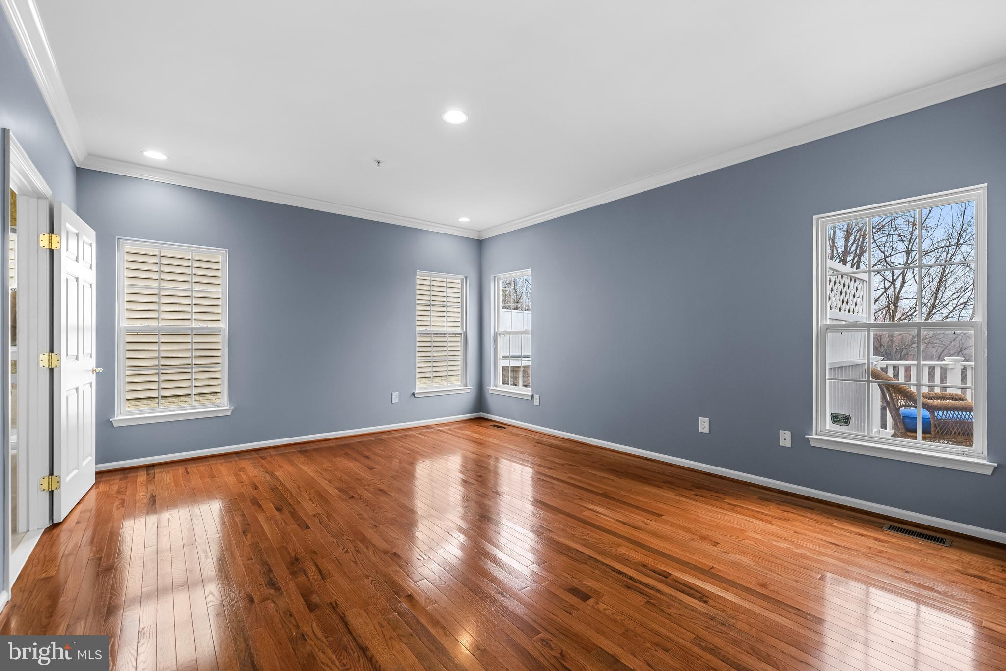 8330 Meadowsweet Road, Unit 8330 Pikesville, MD 21208 - Photo 25 of 55 a view of an empty room with a window and wooden floor