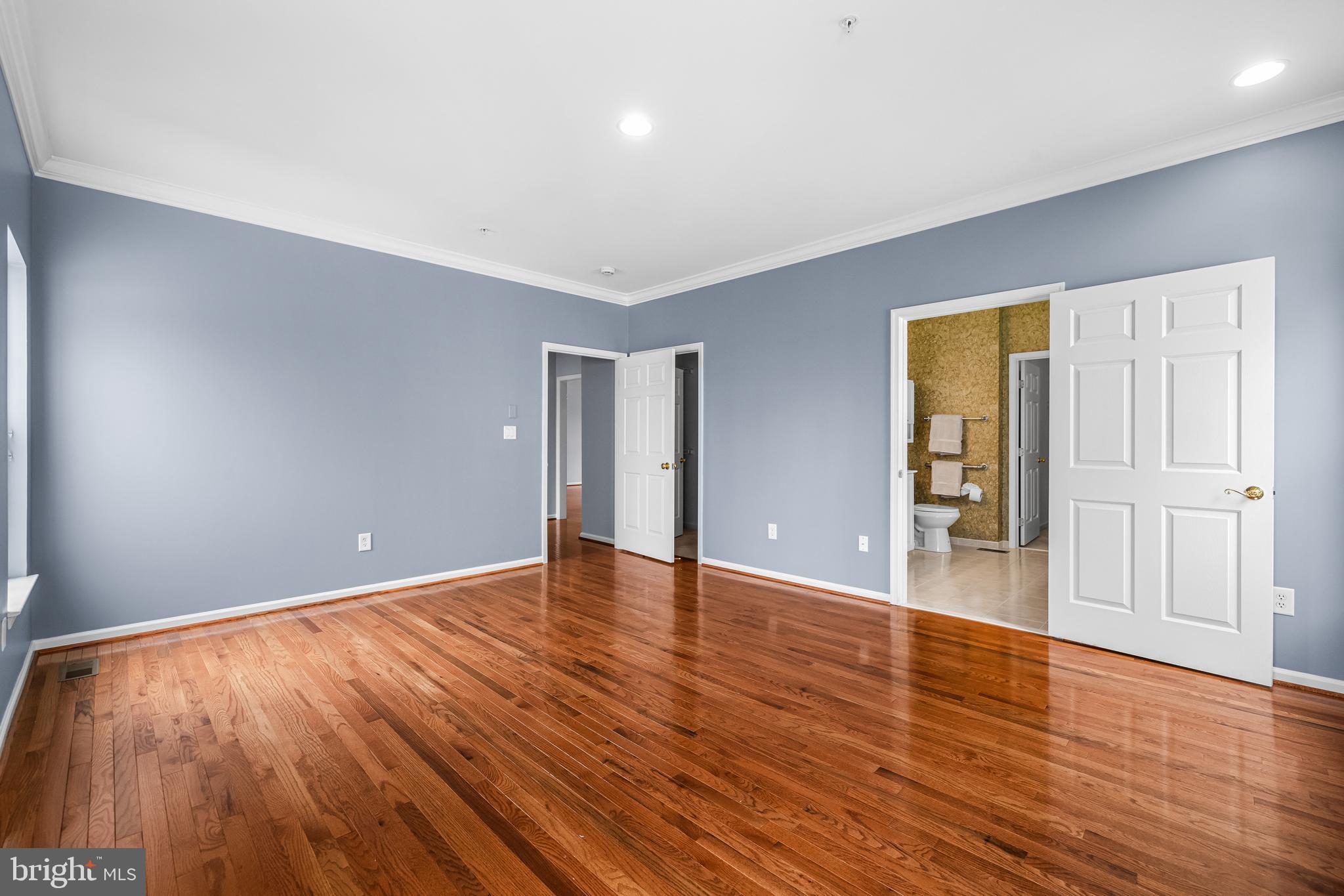 8330 Meadowsweet Road, Unit 8330 Pikesville, MD 21208 - Photo 27 of 55 a view of an empty room with wooden floor and a window