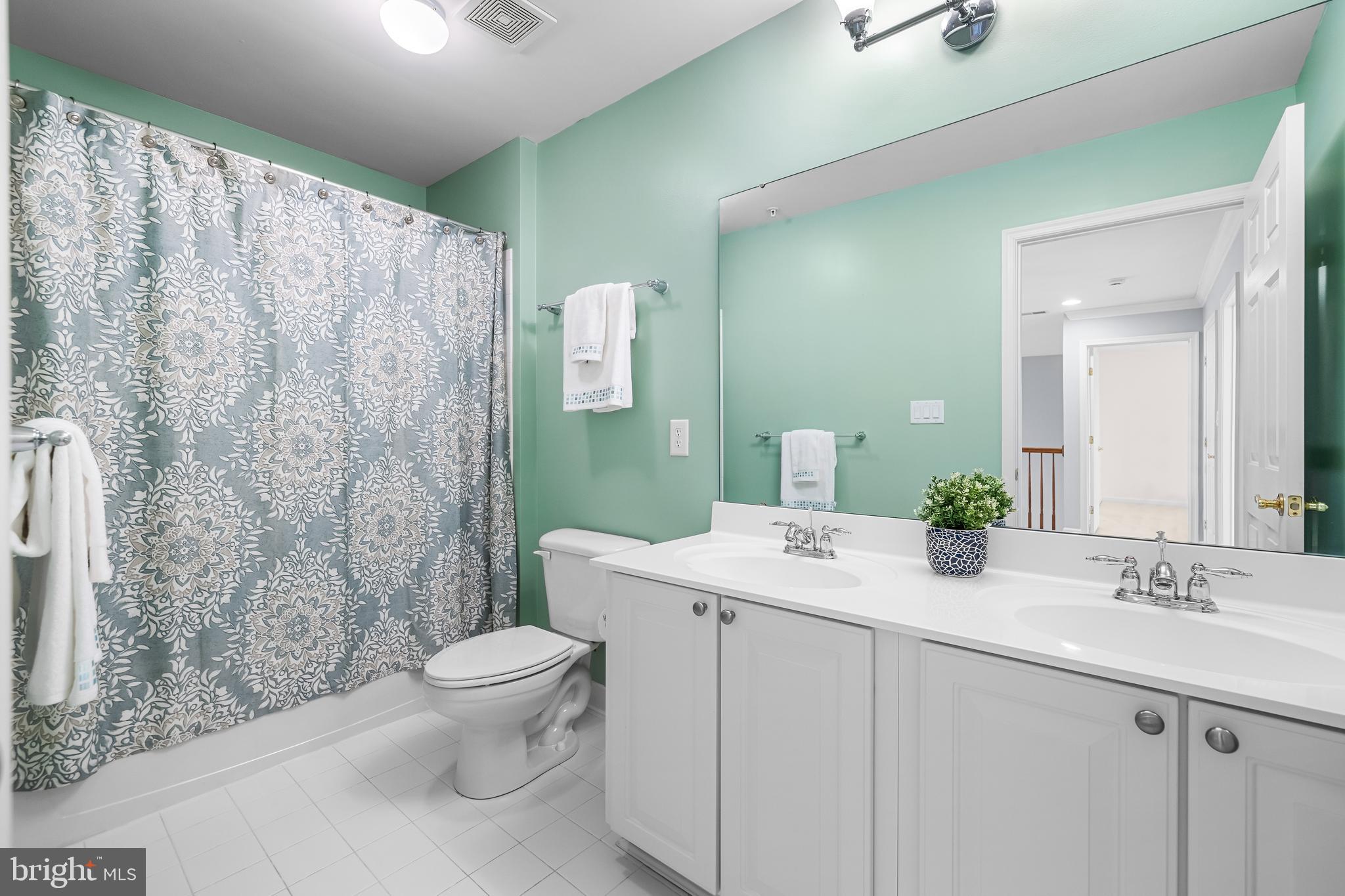 8330 Meadowsweet Road, Unit 8330 Pikesville, MD 21208 - Photo 36 of 55 a bathroom with a granite countertop sink a toilet and a mirror