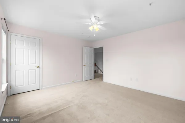 a view of an empty room with a ceiling fan