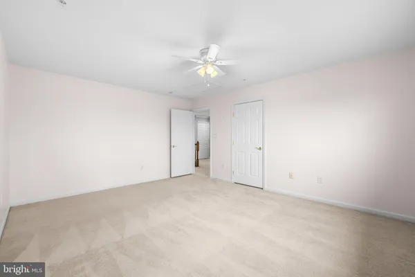 an empty room with a ceiling fan and a window