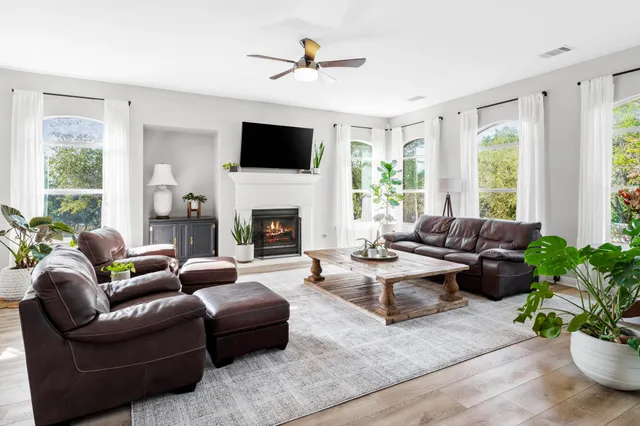 a living room with furniture fireplace and a large window