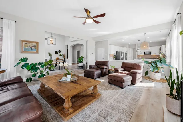 a living room with furniture kitchen view and a potted plant