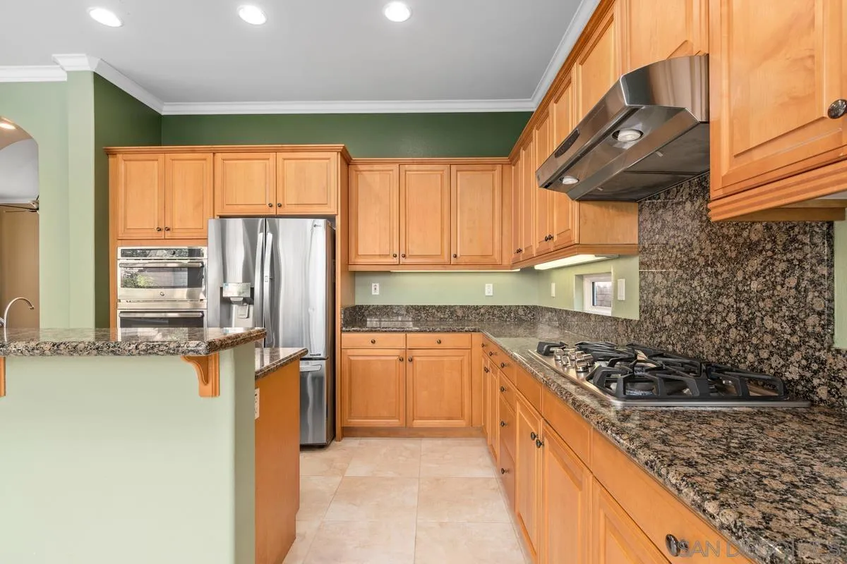 5536 Rabbit Ridge Road San Diego, CA 92130 - Photo 3 of 19 a kitchen with stainless steel appliances granite countertop a stove a sink and a refrigerator