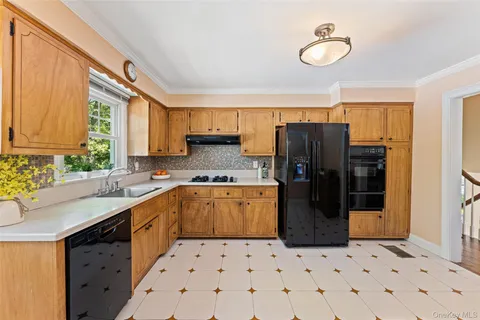 a kitchen with a sink a refrigerator and cabinets