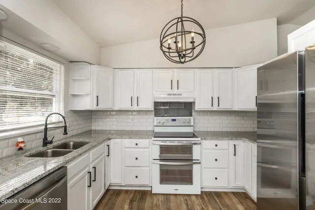 a kitchen with stainless steel appliances a sink a stove and cabinets
