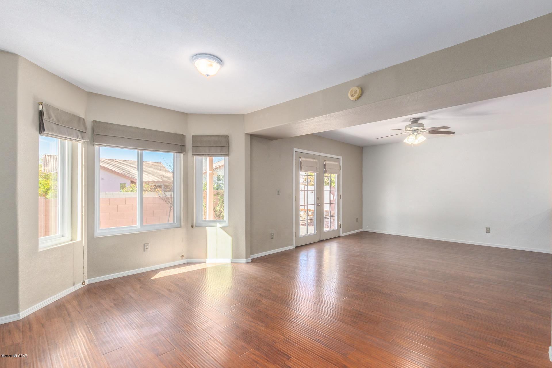 3580 West Sky Ridge Loop Tucson, AZ 85742 - Photo 7 of 29 a view of an empty room with a window and wooden floor