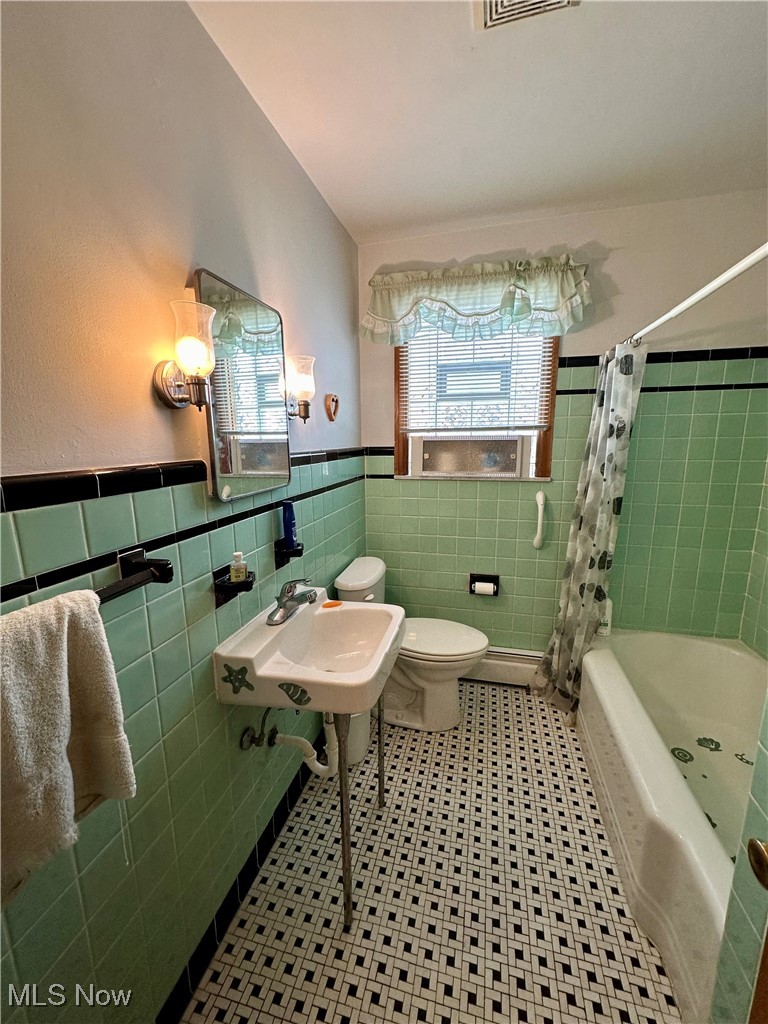 343 Raleigh Avenue Weirton, WV 26062 - Photo 18 of 46 Full bathroom with toilet, sink, decorative backsplash, tile walls, and shower / bath combination with curtain