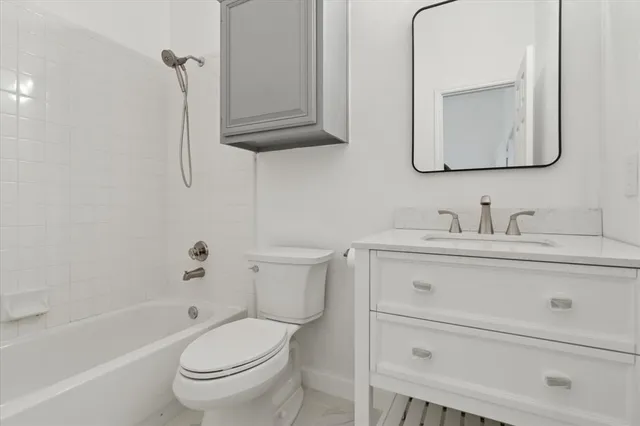 a bathroom with a toilet a sink a bath tub and mirror