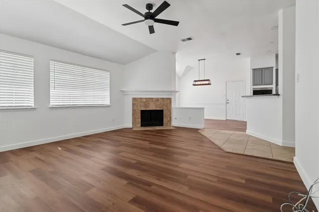 a view of an empty room with a window and fireplace