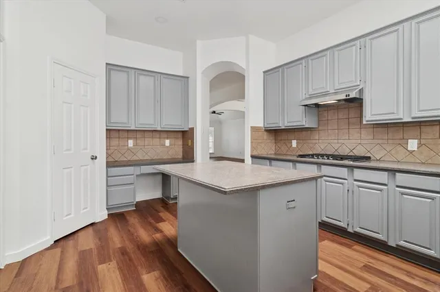 a kitchen with granite countertop a sink cabinets and stainless steel appliances
