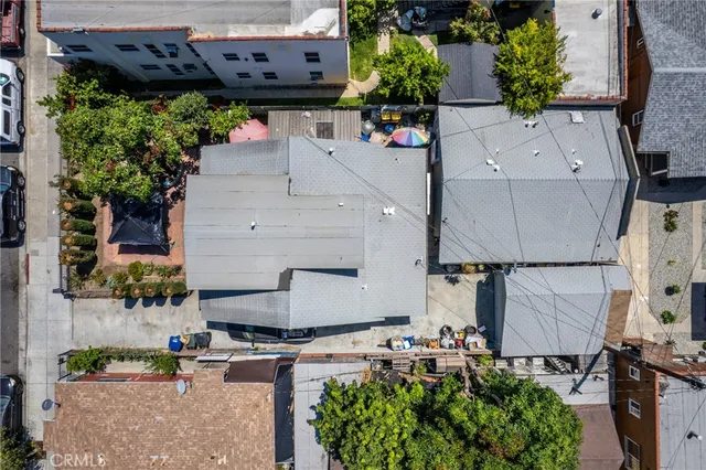 an aerial view of a house with a yard and a large tree
