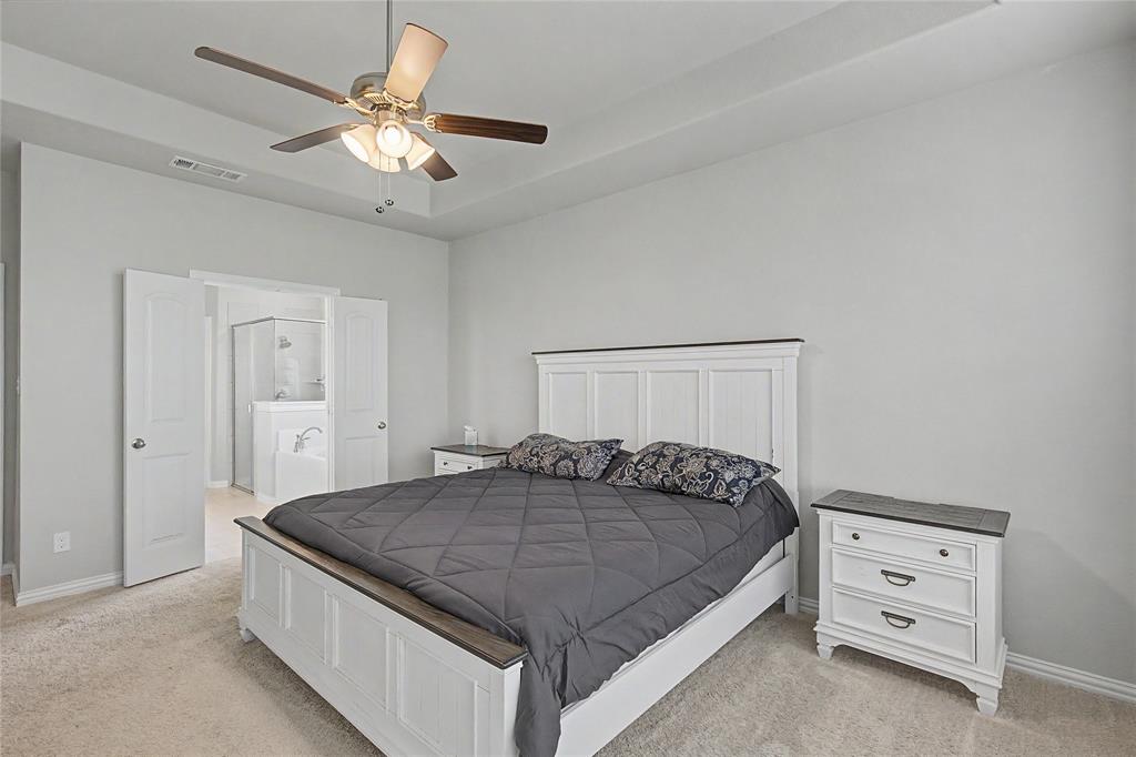 185 Chester Road Springtown, TX 76082 - Photo 23 of 40 Carpeted bedroom featuring a tray ceiling with a ceiling fan, light gray wall paint, and white trim