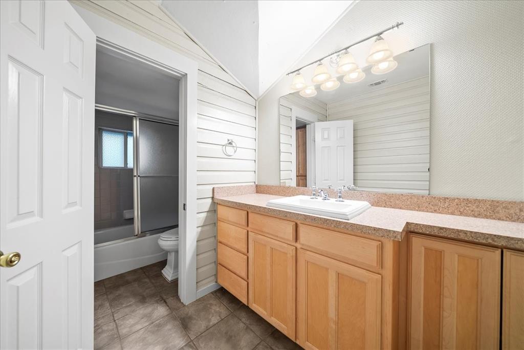 101 North 7th Street Krum, TX 76249 - Photo 9 of 26 Full bath with vanity, combined bath / shower with glass door, and dark tile patterned floors