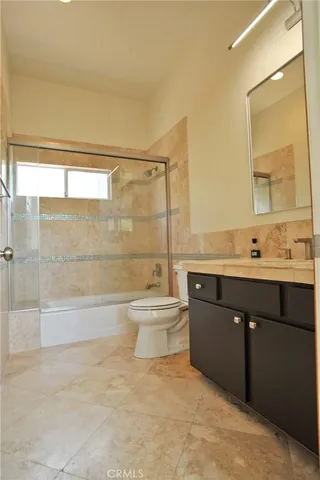 a bathroom with a bathtub sink vanity mirror and toilet