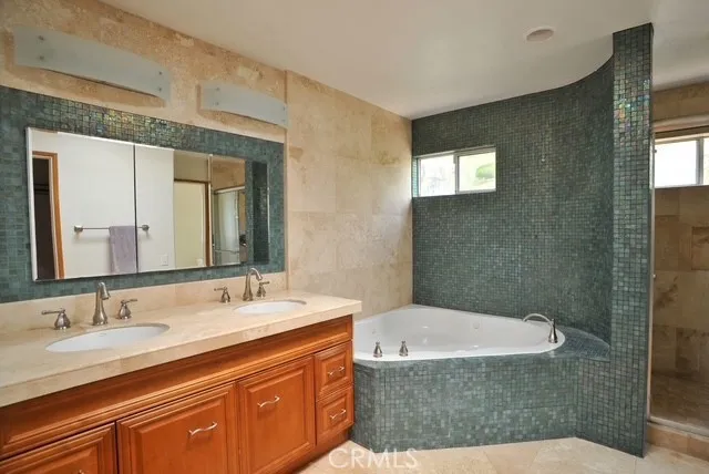 a bathroom with a granite countertop sink a mirror and a bathtub