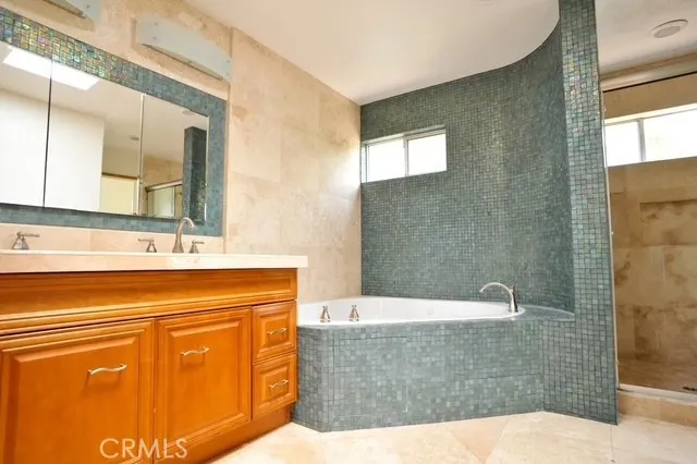 a bathroom with a bathtub sink and mirror