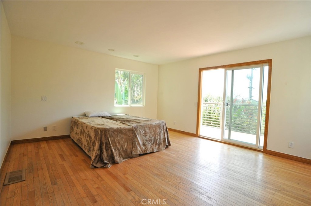1707 Hygeia Avenue Encinitas, CA 92024 - Photo 33 of 41 a spacious bedroom with a bed and wooden floor